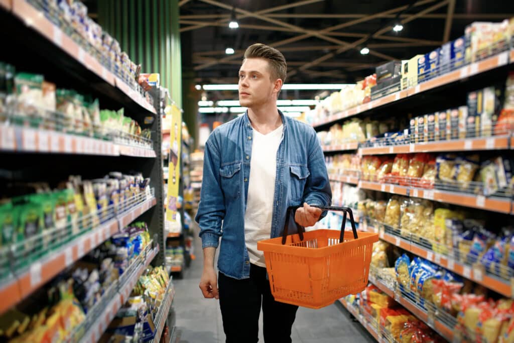 Man shopping for groceries in a store aisle near CollegePlace Uptown