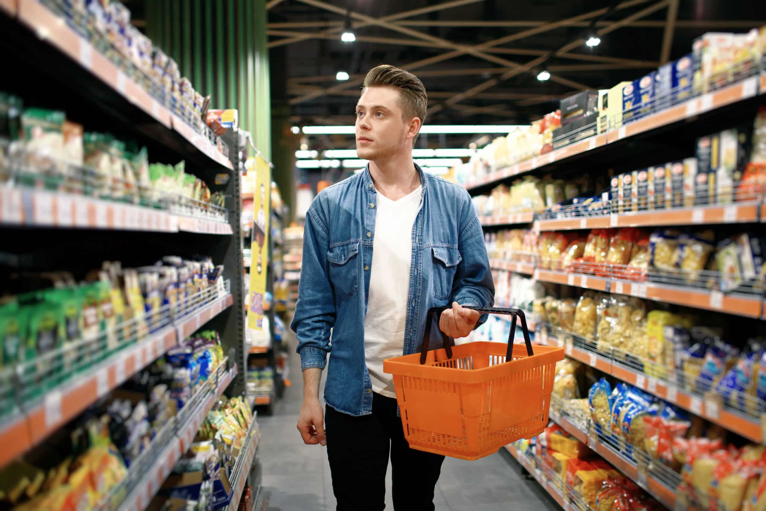 Man shopping for groceries in a store aisle near CollegePlace Uptown